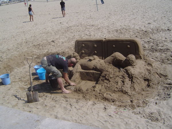 Man making Homer Simpson sandcastle