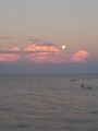 The moon rising as the sun sets