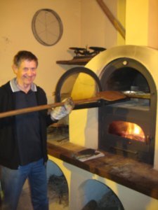 Dad cooking pizza in the wood fired oven