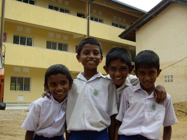 Young boys in front of the new 3 storey classroom block at Siddhartha College.