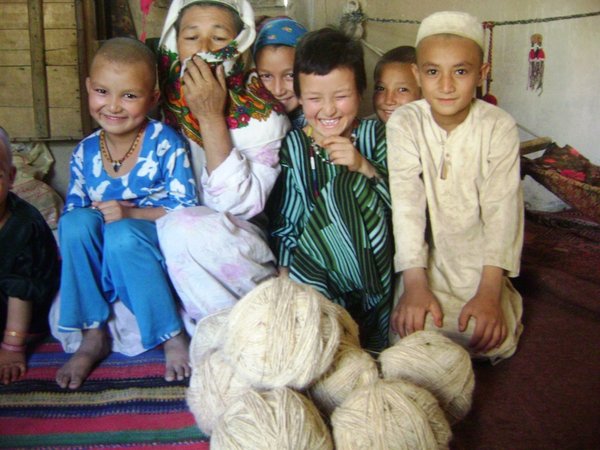 Children with balls of wool for carpet making