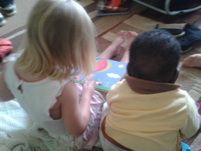 Emma "reading" to a baby at the orphanage