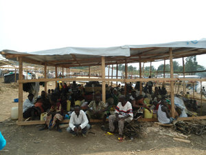 Refugees staking out their space while the shelter is being built over the top of them, Bundibugyo