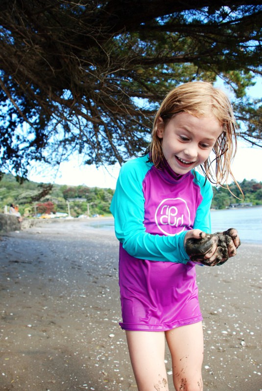 Hayley amazed by black sand, Huia Beach.