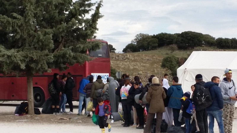 Refugees boarding a bus to travel from an assembly point to the registration centre. It is a 70km journey from the north of the island.