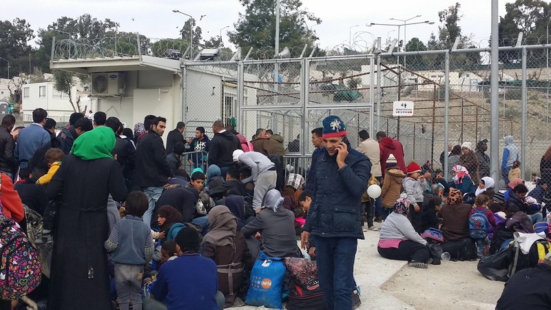 Refugees crowd around the entrance of the registration centre at Moria in Lesbos, Greece. Register then buy a ferry ticket to Athens