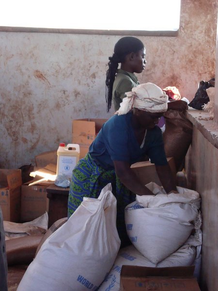 Malawian Red Cross workers rationing out food for distribution to the refugees