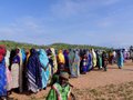Women and children in an IDP site gathered to watch the VIP hubbub
