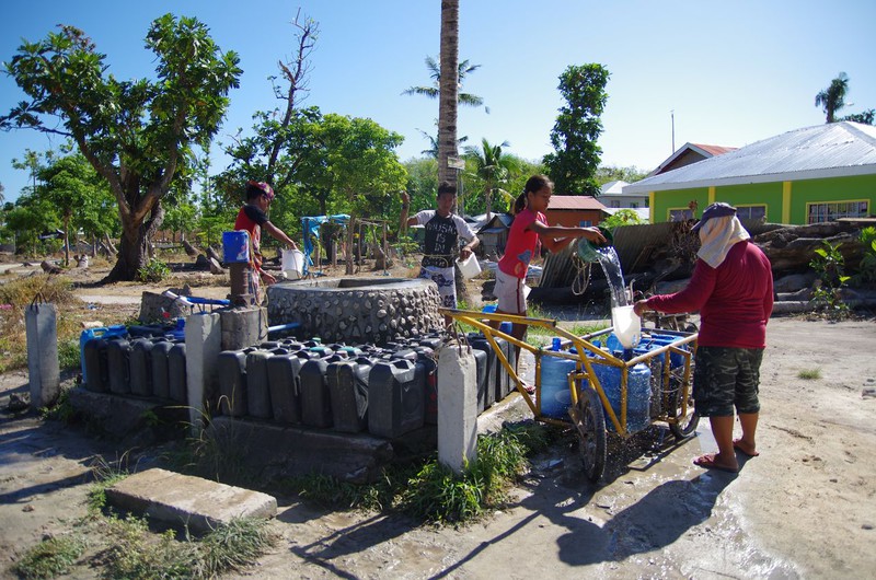 villagers drawing water from a well, malapascua island