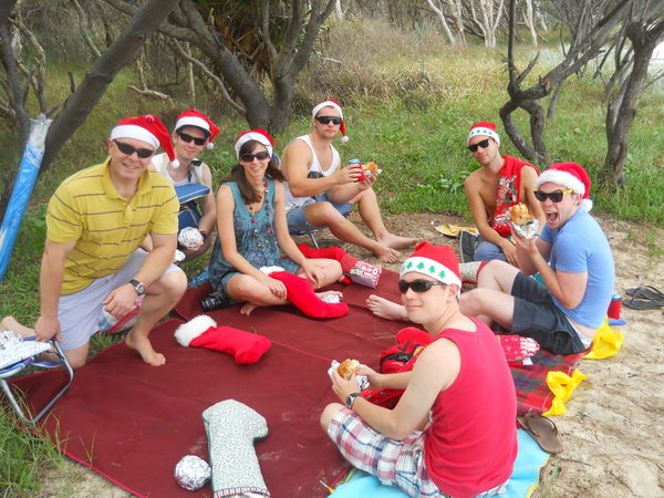Opening presents under the trees on the beach.