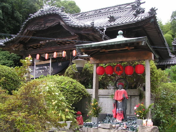 shrine to jizo in foreground, dedicated to lost, miscarried or aborted children