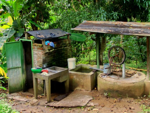 down the hill, this is the well and the bano where i take my bucket baths, mango tree above