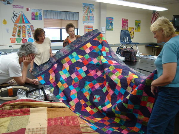 Marilyns Monday night quilting group with the raffle quilt  made by all the girls