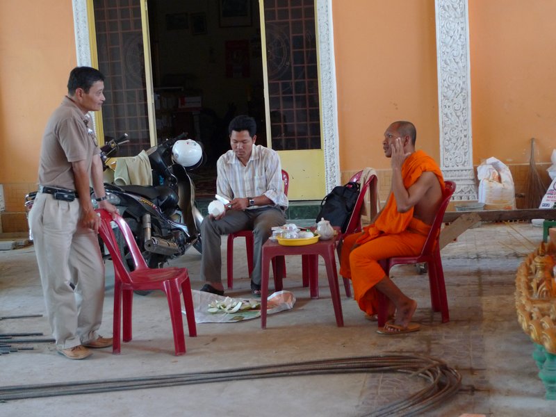 Our guide, a random man and a monk with a cell phone