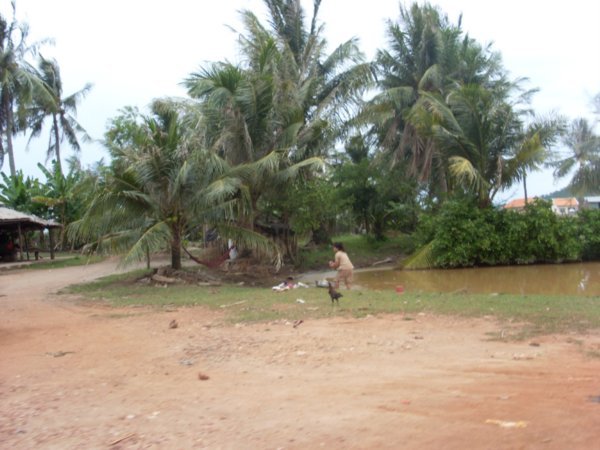 village woman washing clothes in dirty water