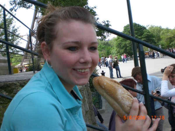 trying to be frnech eating a baguette with i dont know what in side