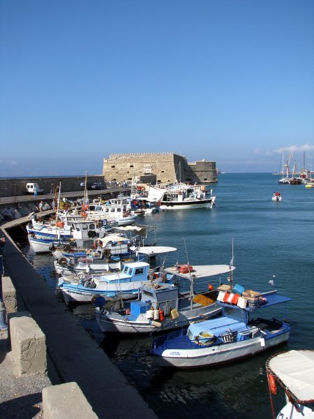 Fishing boats in Heraklion harbour against the backdrop of the walls of the Venetian Fort