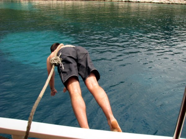 Our deckhand diving in to take a rope ashore to tie up in a sheltered cove on Hvar