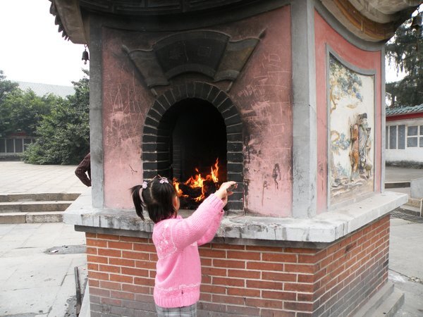 A girl burns paper offerings