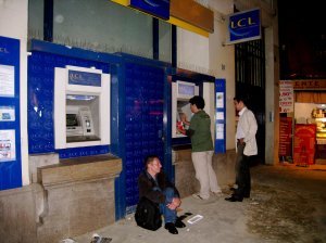 bums sitting between ATM machines