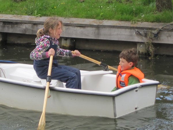 A girl rows her brother through the canals