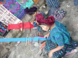 Weaving her beautiful fabrics in the market for the tourists