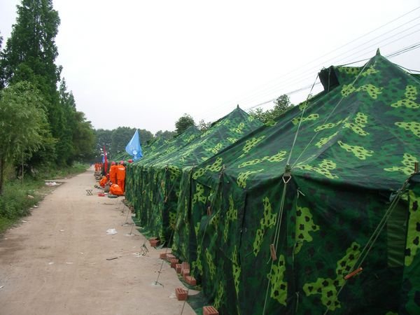 Many tents are erected nearby to house the volunteers who are constructing the temporary homes for 3000 people
