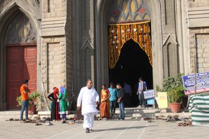Indians leave their shoes in front of the church before entering