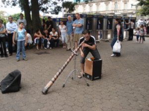 A tico playing didgeridoo with a latino beat