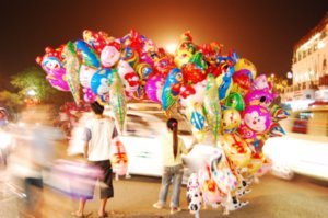 The balloon vendors in the middle of traffic