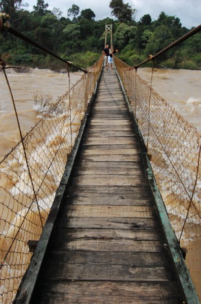 The rickety suspension bridge over the flooding waters