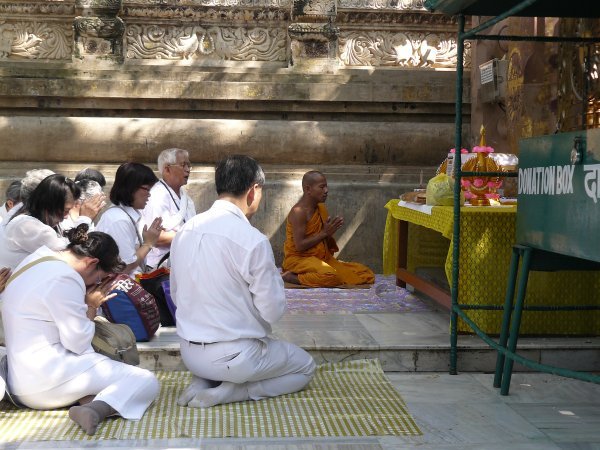 A monk praying with pilgrims