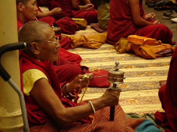 Elderly monk with prayer wheel