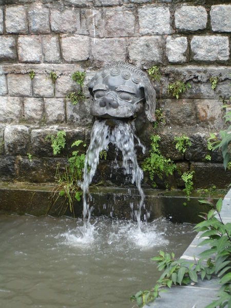 Stone lion water spout at Norbulingka Institute