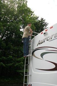 Jason climbing on top of the motor home to check for clearance.