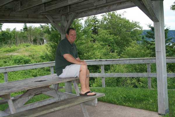 Tim sitting on the picnic table waiting for the others to return.