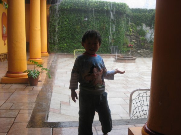 Mexican boy at hostel playing in rain