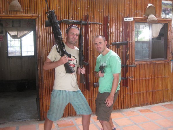 34. Brothers in arms... Mike holding a M16 and AK-47 & me an Uzi, a  shooting range near Phnom Penh