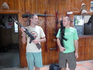 36. Sharing a joke holding guns - Mike with an AK-47 & me with a M16, a shooting range near Phnom Penh