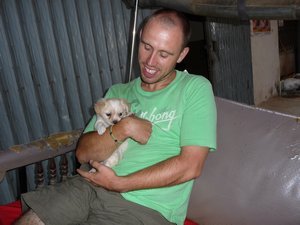 54. Holding a cute puppy in Neng's moto outside the guesthouse in Phnom Penh