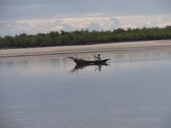 A local villager paddling along the river toward the sea