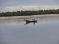 A local villager paddling along the river toward the sea