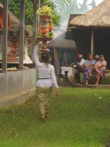 A woman carrying her offerings