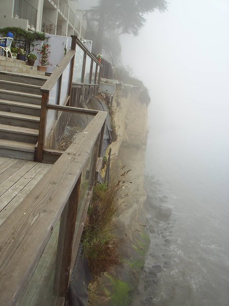 Looking over the railing down towards the ocean through the fog