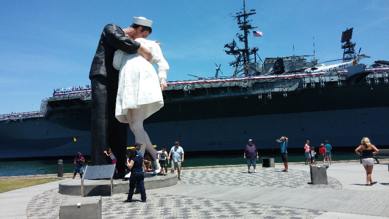 A statue of the iconic image from the end of WWI in front of the USS Midway