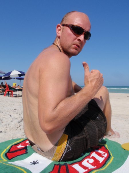 A fat bald guy on the beach
