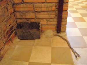The chain which tied prisoners to the floor, and their toilet bucket