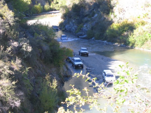 4 WD vehicles ford the river beneath us
