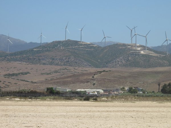 Wind farm on hill behind beach
