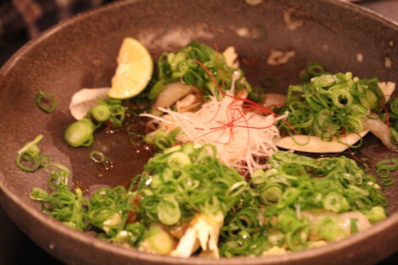 Fugu sashimi w/ green onion on a cabbage leaf